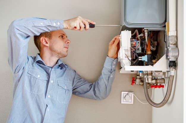 Técnico trabalhando em aquecedor a gás residencial